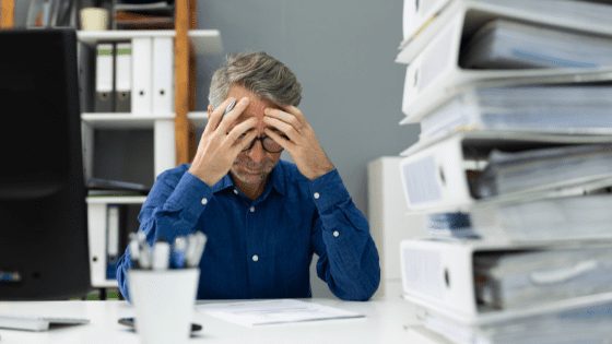 Demotivated-employee-sat-with-head-in-hands.png