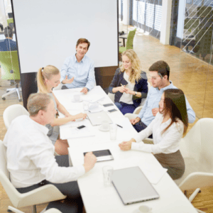 A manager leading a relaxed discussion with their team around a meeting table