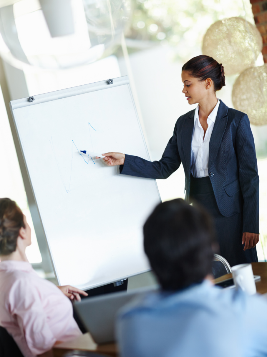 A trainer presenting workplace inclusion data on a flip chart